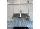 Close-up of a modern stainless steel range hood with a chevron backsplash at 5043 Baywood Ln, Woodstock, GA 30188