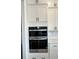 Gourmet kitchen featuring double wall ovens and stylish white cabinetry at 5043 Baywood Ln, Woodstock, GA 30188