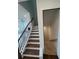 Staircase with wood treads, white risers, and black iron railing at 5043 Baywood Ln, Woodstock, GA 30188