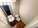 Small powder room with pedestal sink, toilet, and wood flooring at 6636 Saint Jude Dr, Fairburn, GA 30213