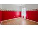bedroom with red walls and wood floors at 1215 Brook Meadow Ct, Lawrenceville, GA 30045