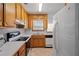 Kitchen boasts wood cabinets, white appliances, and tile floors at 1215 Brook Meadow Ct, Lawrenceville, GA 30045