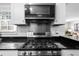 Close-up of a modern stainless steel gas range, oven, and microwave set within white cabinetry at 2732 Suwanee Se Way, Marietta, GA 30067