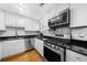 Well-equipped kitchen with stainless steel appliances, white cabinets, and sleek black countertops at 2732 Suwanee Se Way, Marietta, GA 30067