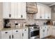 Kitchen boasts white cabinets, granite counters, and herringbone backsplash at 5060 Lloyd Ln, Cumming, GA 30040