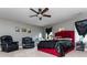 Relaxing main bedroom with a comfortable red bed, two leather recliners, and ceiling fan at 5060 Lloyd Ln, Cumming, GA 30040