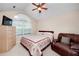 Cozy bedroom featuring a ceiling fan, a large window, and a comfy leather chair at 2191 Rockbridge Sw Rd # 202, Stone Mountain, GA 30087