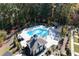 Aerial view of a community pool and pool house nestled among mature trees at 418 Townly, Alpharetta, GA 30009