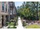Attractive brick townhomes feature well-kept landscaping along a sidewalk at 418 Townly, Alpharetta, GA 30009