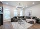 Cozy living room with a large sectional sofa, modern chandelier, and hardwood flooring at 418 Townly, Alpharetta, GA 30009