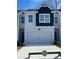 Charming townhome showcasing a two-car garage, blue and gray exterior, and well-maintained landscaping at 1621 Aiden Way # 57, Conyers, GA 30013