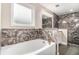 Luxurious main bath featuring a soaking tub and walk-in shower with marble tile surround at 692 Rose Palm Ln, Atlanta, GA 30315