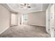 Spacious main bedroom with a tray ceiling, ceiling fan, carpeted floor, and an ensuite bathroom entrance at 692 Rose Palm Ln, Atlanta, GA 30315