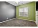 Bright bedroom with gray and green walls, carpet flooring, and a large window at 125 E Woodland Mnr, Temple, GA 30179