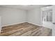 Finished basement space with laminate flooring adjacent to a bathroom with tiled shower at 1506 Country Ct, Auburn, GA 30011