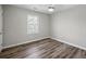 Bright bedroom featuring modern gray walls, stylish ceiling fan and wood-look laminate flooring at 1506 Country Ct, Auburn, GA 30011