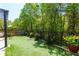 A lush backyard features artificial grass, bordered by vibrant plants and a secure black fence at 327 Balaban Cir, Woodstock, GA 30188