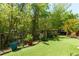 A lush backyard features artificial grass, bordered by vibrant plants and a secure black fence at 327 Balaban Cir, Woodstock, GA 30188