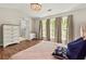 Cozy bedroom boasts wood floors, soft lighting, and large windows with natural light at 327 Balaban Cir, Woodstock, GA 30188