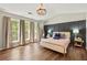 Bedroom with hardwood floors, stylish paneling, and three large windows at 327 Balaban Cir, Woodstock, GA 30188