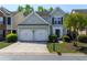 Charming two-story home featuring a two-car garage, lush landscaping, and a welcoming front entrance at 327 Balaban Cir, Woodstock, GA 30188