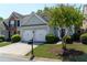 Inviting home with a two-car garage, a healthy tree, and beautiful green shrubs in a quiet neighborhood at 327 Balaban Cir, Woodstock, GA 30188