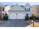 Two-story house with light green siding, white double garage doors, and landscaping at 327 Balaban Cir, Woodstock, GA 30188