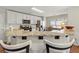 A kitchen breakfast bar features granite countertops, wooden chairs, and stainless steel appliances at 327 Balaban Cir, Woodstock, GA 30188