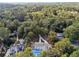 Aerial view of home with backyard pool, spacious driveway and lush greenery at 4395 Woodland Brook Se Dr, Atlanta, GA 30339