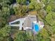 Aerial view of home with large pool, spacious driveway, and wooden pergola at 4395 Woodland Brook Se Dr, Atlanta, GA 30339