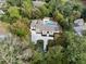 Aerial view of a home surrounded by mature trees, pool, and large driveway at 4395 Woodland Brook Se Dr, Atlanta, GA 30339