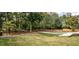 Expansive backyard featuring lush greenery, mature trees, and a winding driveway at 4395 Woodland Brook Se Dr, Atlanta, GA 30339