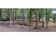Wooded backyard with foliage and a small creek and a peek at the driveway and home at 4395 Woodland Brook Se Dr, Atlanta, GA 30339