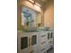 Bright bathroom featuring double vanity, modern sinks, gold fixtures, and well-lit mirror at 4395 Woodland Brook Se Dr, Atlanta, GA 30339