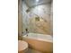 Bathroom boasts elegant marble tile shower with gold fixtures and built-in shelf at 4395 Woodland Brook Se Dr, Atlanta, GA 30339