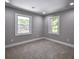 Cozy bedroom with two windows providing natural light, carpet flooring, and neutral walls at 4395 Woodland Brook Se Dr, Atlanta, GA 30339
