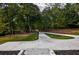Expansive driveway featuring lush greenery, mature trees, and a winding path at 4395 Woodland Brook Se Dr, Atlanta, GA 30339