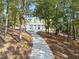 Exterior shot of the home from a ground view surrounded by trees and pathway at 4395 Woodland Brook Se Dr, Atlanta, GA 30339