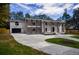 Elegant home with a brick exterior, columns, and modern garage door, set on a tree-lined lot at 4395 Woodland Brook Se Dr, Atlanta, GA 30339
