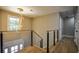Open hallway with hardwood floors, modern railing, and stylish chandelier lighting at 4395 Woodland Brook Se Dr, Atlanta, GA 30339