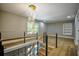 Upstairs hallway featuring modern railing, hardwood floors, stylish lighting, and a spacious open area at 4395 Woodland Brook Se Dr, Atlanta, GA 30339