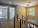 Bright hallway featuring modern lighting, wood floors and metal railing up stairs at 4395 Woodland Brook Se Dr, Atlanta, GA 30339