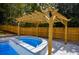 Hot tub featuring a wooden pergola, wooden fence, and sleek modern design at 4395 Woodland Brook Se Dr, Atlanta, GA 30339