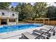 Backyard view with a pool, hot tub, wooden fence, lounge chairs, and a pergola at 4395 Woodland Brook Se Dr, Atlanta, GA 30339