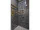 Sleek glass shower featuring gray marble-style tile, gold accents and hardware at 4395 Woodland Brook Se Dr, Atlanta, GA 30339