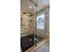 Shower with black hexagonal floor tiles and white marble-look shower surround with gold fixtures at 4395 Woodland Brook Se Dr, Atlanta, GA 30339