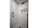 Luxurious tiled shower with glass door, rainfall showerhead, and built-in niche at 4395 Woodland Brook Se Dr, Atlanta, GA 30339