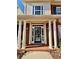 Elegant front entry with columns, a blue door, and a welcoming mat at 9801 Waters Edge Pointe, Villa Rica, GA 30180