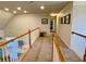 Upstairs hallway with carpet, railing, and artwork at 9801 Waters Edge Pointe, Villa Rica, GA 30180