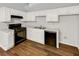Kitchen with white cabinets, black appliances and wood floors at 2845 Robinson Wood Dr, Riverdale, GA 30296